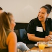 Woman speaking to two other people at a table