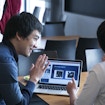 Two Kavli fellows in front of a computer