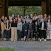 A group photo of thirty people gathered in front of a barn