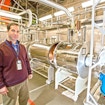 Princeton physicist Chris Tully stands in the PTOLEMY laboratory at the Princeton Plasma Physics Laboratory. Behind him are powerful superconducting magnets on either side of the vacuum chamber.