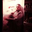 A man sitting in a refrigerator with something in his mouth