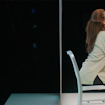 profile of a woman sitting on a metal chair