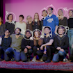 group of people standing on a stage with a carpet on the ground